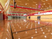 the gymnasium of a college sports complex with a basketball court and an indoor gym, with hardwood and steel floors