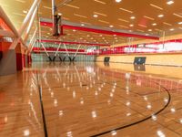 the gymnasium of a college sports complex with a basketball court and an indoor gym, with hardwood and steel floors