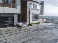 the exterior and landscape of a modern house in los angeles, california with stone and wood