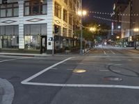 an empty street with people walking and a traffic light at night, on an otherwise quiet street corner