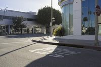 an empty street is shown with signs painted on the pavement along it with trees and buildings in the background