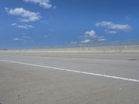 empty highway with one lane being separated by a long bridge on a sunny day with blue sky