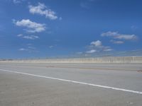 empty highway with one lane being separated by a long bridge on a sunny day with blue sky