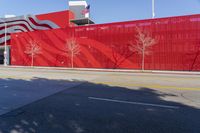 a very large red building with a huge graphic on the side of it is in the middle of a street