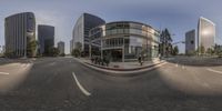 there is a large circular glass building in the middle of the street and a sidewalk to the left