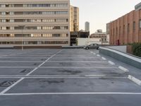 this is an empty parking lot with several cars in it and the buildings behind it