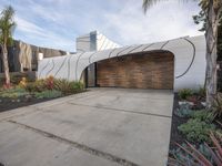 a large garage is next to a tree and some plants in the yard that surround the building