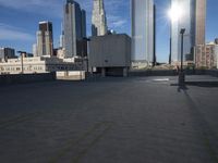 an empty parking lot with some buildings in the background on a bright sunny day and sunlight