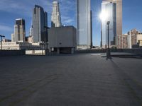 an empty parking lot with some buildings in the background on a bright sunny day and sunlight