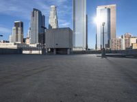 an empty parking lot with some buildings in the background on a bright sunny day and sunlight