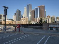 a parking lot has two parking meter and two red telephone booths in it, the city behind it