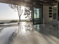 the sun reflects on the floor of an open air covered building that overlooks the view