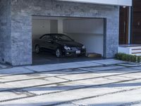 the exterior and landscape of a modern house in los angeles, california with stone and wood