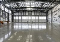 a large warehouse with a large mirror on the floor in it and multiple windows inside