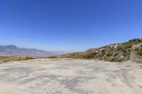 empty parking lot with mountains and blue sky in the background at this remote, californian desert