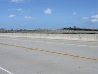 a person riding a motorcycle down a highway in the sun while on their cell phone