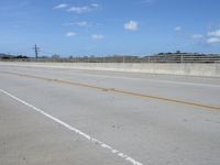 a person riding a motorcycle down a highway in the sun while on their cell phone