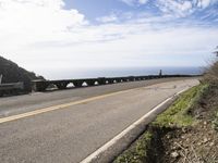 a road in front of a large body of water and a bridge on both sides