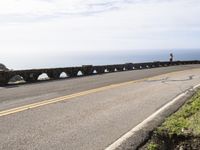 a road in front of a large body of water and a bridge on both sides