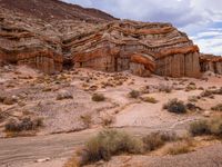 the desert landscape is dotted with rocks and weeds in this image are rocks, and shrubs and trees on the other side