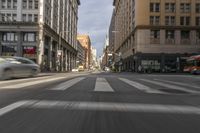 an intersection on a city street filled with traffic and buildings in the distance is blurry