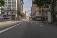 an intersection on a city street filled with traffic and buildings in the distance is blurry