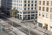 a parking lot has two parking meter and two red telephone booths in it, the city behind it