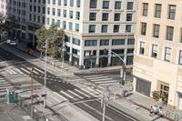 a parking lot has two parking meter and two red telephone booths in it, the city behind it