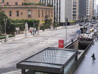 a long bus stop next to the side of a street filled with pedestrians and cars