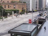 a long bus stop next to the side of a street filled with pedestrians and cars