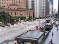 a long bus stop next to the side of a street filled with pedestrians and cars