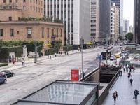 a long bus stop next to the side of a street filled with pedestrians and cars