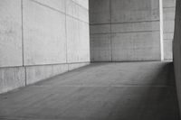 a person riding a skateboard in a concrete area on the sidewalk of a building