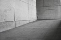 a person riding a skateboard in a concrete area on the sidewalk of a building