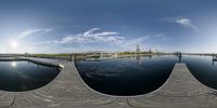 two fisheyes view of a dock at a lake and a skyline in the background