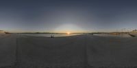 a view of a beach from a boat ramp at sunrise, looking like a panorama of the sunsets