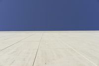 a white building that has been painted with grey paint and has a large area of dirt