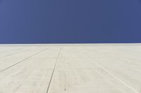 a white building that has been painted with grey paint and has a large area of dirt