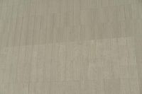 a white building that has been painted with grey paint and has a large area of dirt