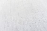 a white building that has been painted with grey paint and has a large area of dirt