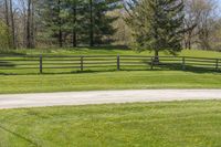 there is a fence that separates the parking lot between the pastures and trees, making it appear to be empty