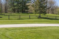 there is a fence that separates the parking lot between the pastures and trees, making it appear to be empty