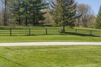 there is a fence that separates the parking lot between the pastures and trees, making it appear to be empty