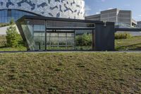 a large glass building with geometric designs on it's side and a long driveway leading to it