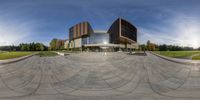 a very nice building with a large circle on it's sides and trees near by