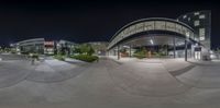 many people at the entrance of an airport at night time in this mirror image, taken with fisheye camera