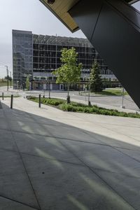 a man on his skateboard next to an airport terminal building with some trees and bushes