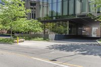 there is a yellow light post on the sidewalk in front of a building that looks like a tunnel