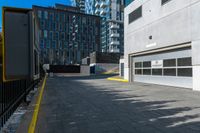 a parking garage is next to an industrial warehouse building with large windows in it, on the side of a city street