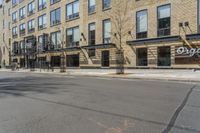 a street in the city with buildings and fire escape stairs on either side of the road